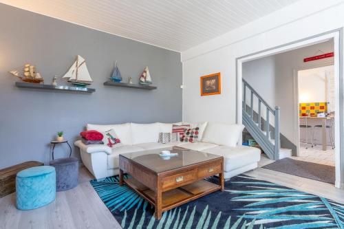 a living room with a white couch and a table at Maison Gavres - Bord de mer in Gâvres