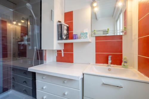 a bathroom with a sink and a shower at Maison Gavres - Bord de mer in Gâvres
