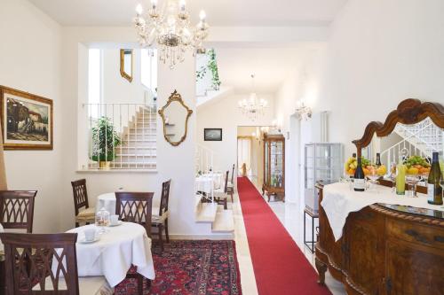 ein Esszimmer mit 2 Tischen und einem roten Teppich in der Unterkunft Villa dei Poeti in La Spezia