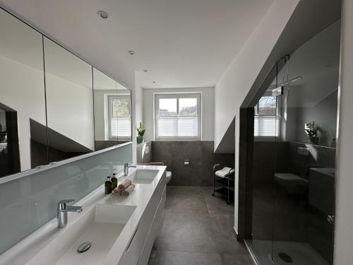 a bathroom with two sinks and a large mirror at Zum Wilzenberg in Schmallenberg