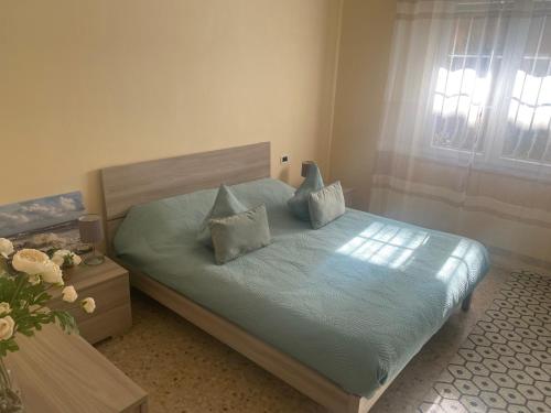 una camera da letto con un letto con lenzuola e cuscini blu di New apartment next to the sea a Bordighera
