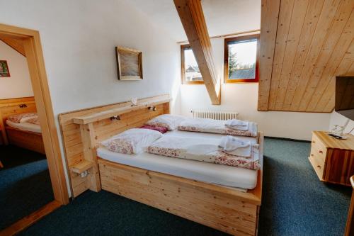 a bedroom with two beds in a room with wooden walls at Penzión Sova Ždiar in Ždiar