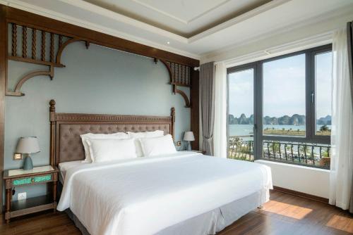 ein Schlafzimmer mit einem großen Bett und einem großen Fenster in der Unterkunft Charmhill Hotel - Tuần Châu in Hạ Long