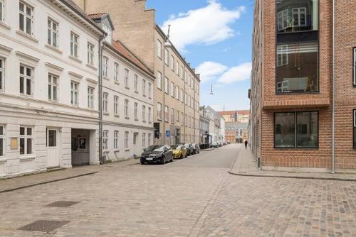 a city street with buildings and cars parked on the street at Apartment Near Pedestrian Street In Aalborg in Aalborg