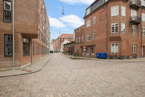 an empty street in a city with brick buildings at Apartment Near Pedestrian Street In Aalborg in Aalborg