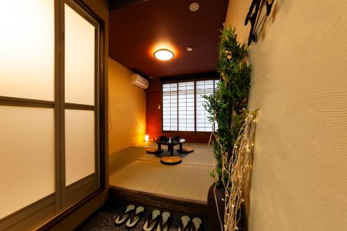 un pasillo con una habitación con una mesa y plantas en おやど紀伊国屋伊勢町, en Asahimachi