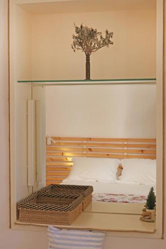 a bedroom with a bed with a tree on the wall at San Nikolas view guest house in Ermoupoli
