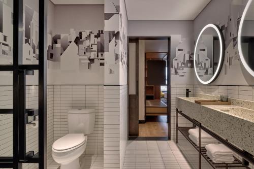 a bathroom with a toilet and a sink and mirrors at Caption by Hyatt Zhongshan Park Shanghai in Shanghai