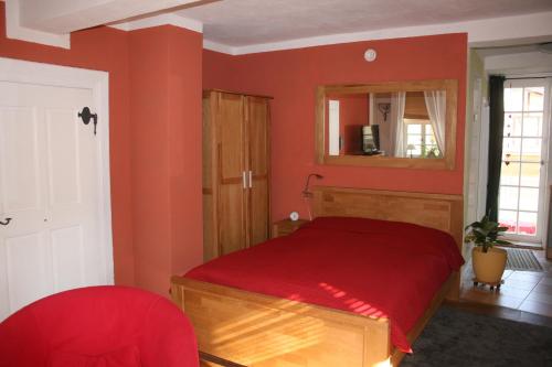 Dormitorio rojo con cama y espejo en Neele, en Lauterbach