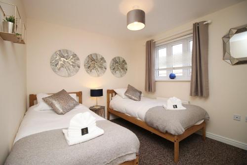 two twin beds in a room with a window at Sleeps 6 - Argosy Way by Tŷ SA in Newport