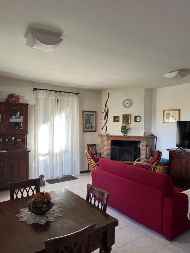 sala de estar con sofá rojo y mesa en Appartamento tra il borgo e il lago, en Anguillara Sabazia