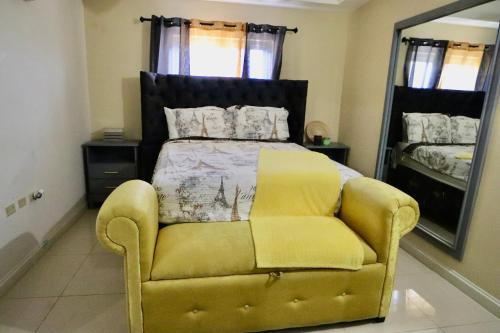 1 dormitorio con 1 cama y 1 silla amarilla en Ruthven Towers, en Kingston
