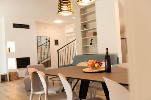 uma sala de jantar com uma mesa e uma garrafa de vinho em Neue VILLA ROSE Fazana em Pula