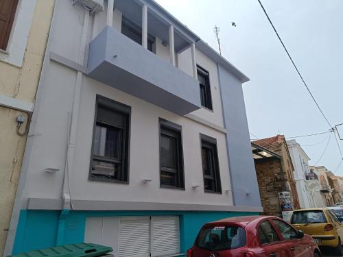 a building with a red car parked in front of it at DATA Maisonettes and more in Chios
