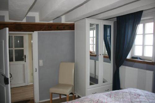 1 dormitorio con 1 cama, 1 silla y ventanas en Eulennest, en Lauterbach