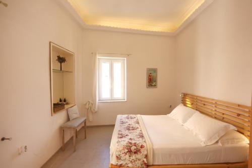 a bedroom with a bed and a window at San Nikolas view guest house in Ermoupoli