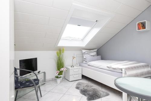 a small attic bedroom with a bed and a window at Ferienwohnung Hoffmann in Netphen