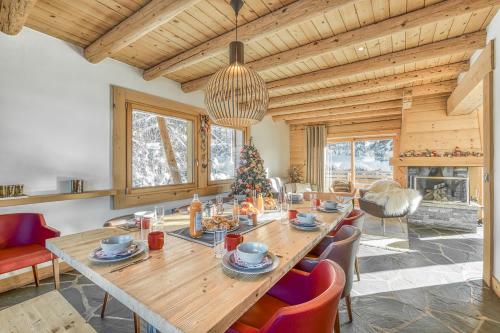 une salle à manger avec une table en bois et un arbre de Noël dans l'établissement Chalet Nepal, à Megève