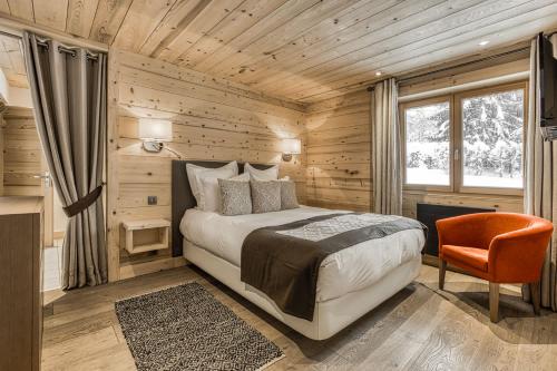 une chambre avec un lit, une chaise et une fenêtre dans l'établissement Chalet Nepal, à Megève