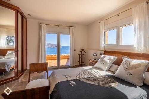 a bedroom with a bed with a view of the ocean at Villa Estrella de Moraira by Abahana Luxe in Moraira