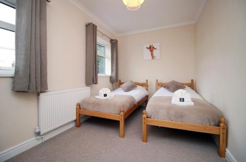 2 Einzelbetten in einem Zimmer mit Fenster in der Unterkunft Keats Retreat by Tŷ SA in Newport