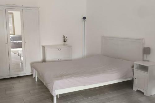 OpenSpace Etna في فياغراندي: غرفة نوم بيضاء مع سرير أبيض وخزانة