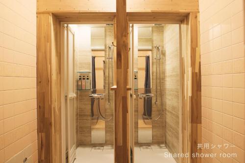 a bathroom with three shower stalls in a room at Hanaguri-しまなみ海道スマート旅館 in Ikata