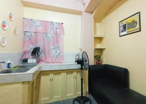 eine Küche mit einem Waschbecken und einem rosa Vorhang in der Unterkunft Avong Tako in Baguio City