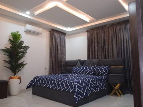 um quarto com uma cama com um edredão azul em Dixonlux Apartments em Abuja