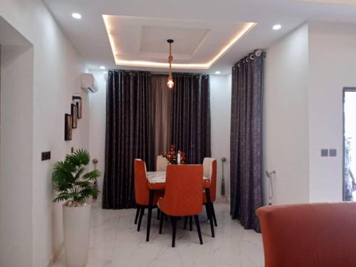 uma sala de jantar com uma mesa e cadeiras laranja em Dixonlux Apartments em Abuja
