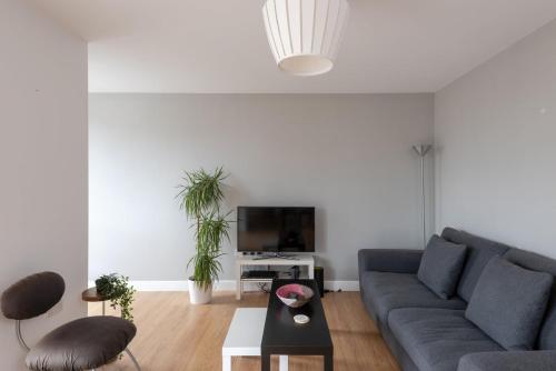 ein Wohnzimmer mit einem Sofa und einem TV in der Unterkunft GuestReady - London Urban Retreat at East End in London