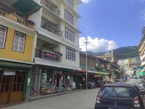 a car parked on a city street with buildings at Hotel Cozi Inn in Bomdila