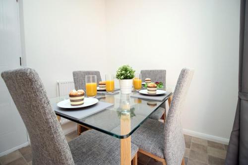 comedor con mesa de cristal y sillas en Langstone Close by Tŷ SA en Llanwern