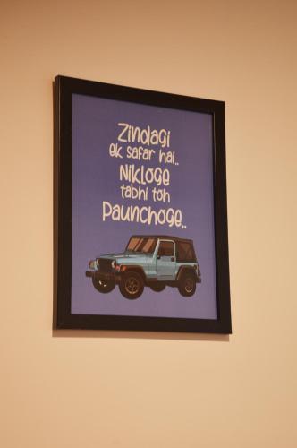 a framed picture of a car on a wall at Manali Outdoor Retreat by Sheosante in Manāli