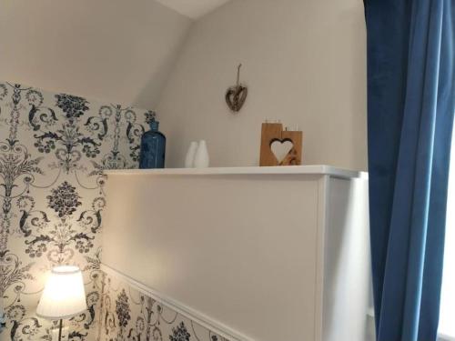 a white staircase with a lamp and a wall at La Croix Douillet in Gavray