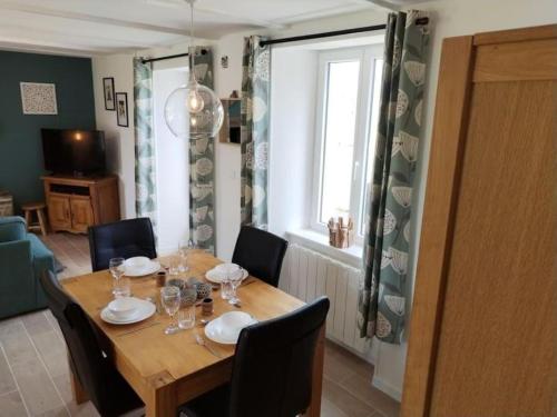 a dining room with a table with chairs and a window at La Croix Douillet in Gavray
