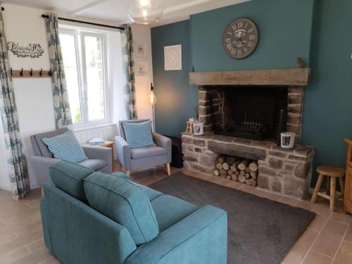 a living room with a blue couch and a fireplace at La Croix Douillet in Gavray