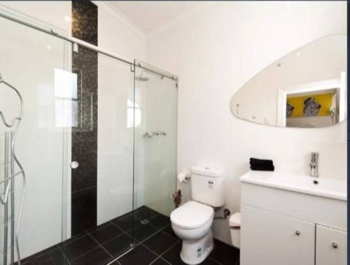 a bathroom with a toilet and a sink and a shower at Subiaco 1bd In Heritage Home Gem in Perth