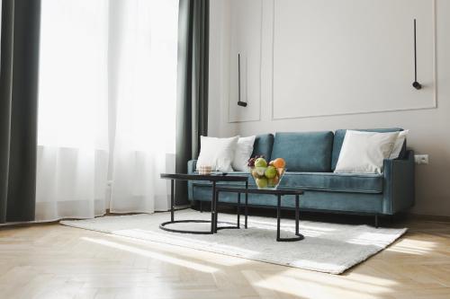 Copernicus House في كراكوف: غرفة معيشة مع أريكة زرقاء وطاولة