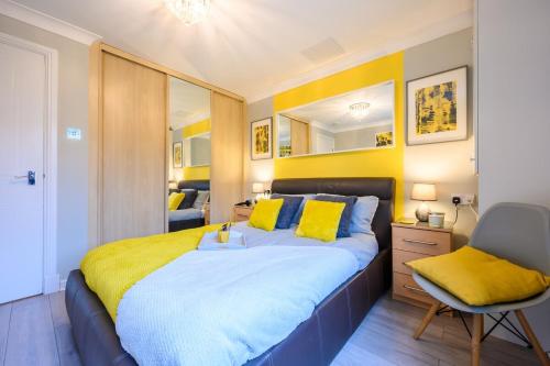 a bedroom with a large bed with yellow pillows at Stadium Way by Tŷ SA -Cardiff Central with Parking in Cardiff
