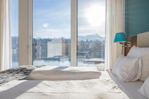 a bedroom with a bed and a large window at Boutique Apartments Velden in Velden am Wörthersee