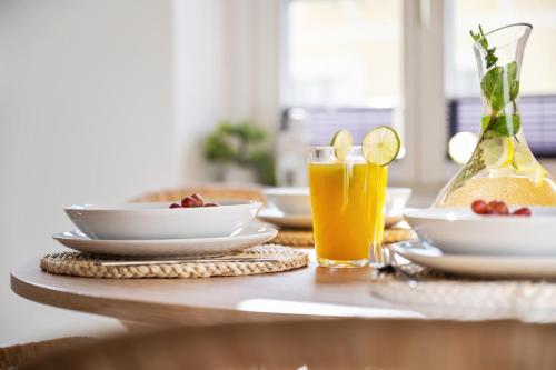 una mesa con platos y un vaso de zumo de naranja en WohnTraum Refugium, Altstadt, en Meißen