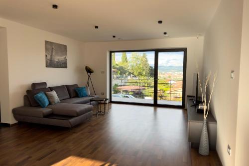 een woonkamer met een bank en een glazen schuifdeur bij Villa Maris in Koper