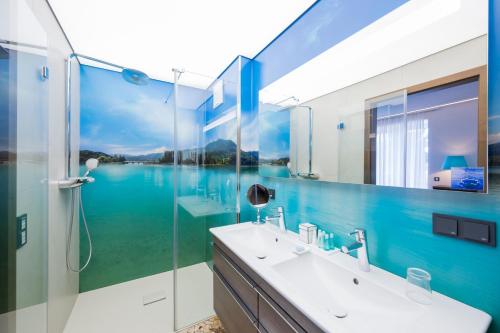 a bathroom with a sink and a glass shower at Boutique Apartments Velden in Velden am Wörthersee