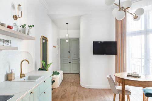 Copernicus House في كراكوف: مطبخ أبيض مع حوض وطاولة