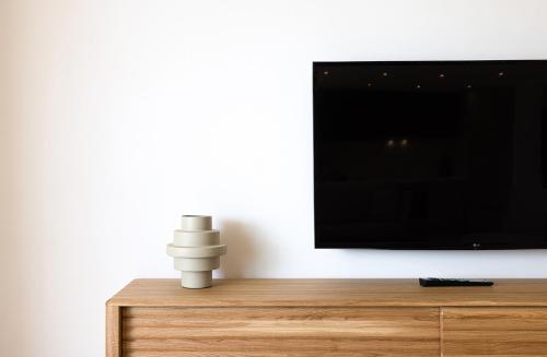 a flat screen tv sitting on top of a wooden dresser at Aqua Apartments Vento, Marbella in Marbella