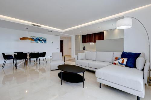 a living room with a white couch and a table at Aqua Apartments Vento, Marbella in Marbella