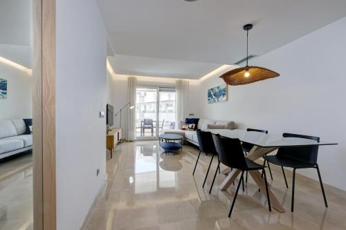 a dining room and living room with a table and chairs at Aqua Apartments Vento, Marbella in Marbella