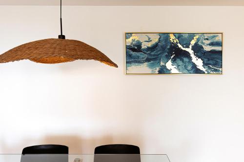 Światło wiszące na ścianie z obrazem w obiekcie Aqua Apartments Vento, Marbella w Marbelli