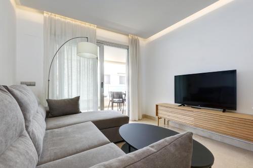 a living room with a couch and a flat screen tv at Aqua Apartments Vento, Marbella in Marbella